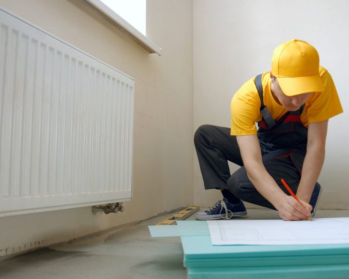 Builder working with blueprint indoors.